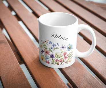 Preview: Personalisierte Tasse mit Aquarellblumen und Name – Frühling im Becher | Geschenk für Naturliebhaber Preview: Weiße Keramiktasse mit farbenfrohem Aquarellblumen-Motiv und personalisiertem Namen „Milena“, fotografiert auf einem Holztisch.